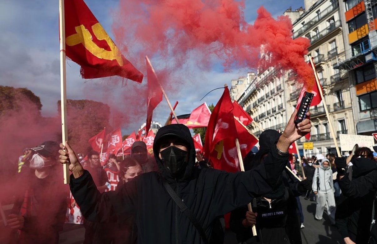 Protest crowd with signs and flags, France October 2026