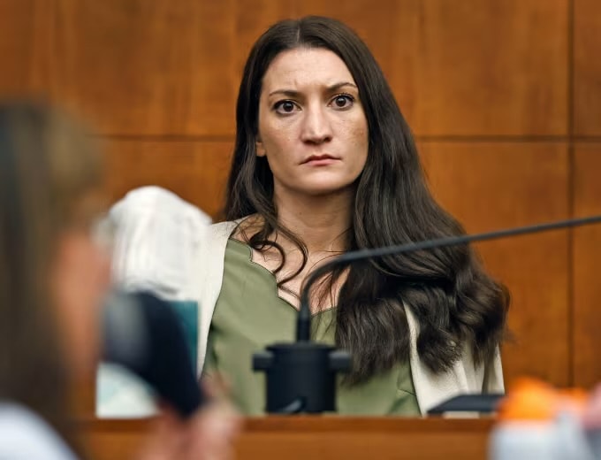 Woman seated in courtroom witness stand